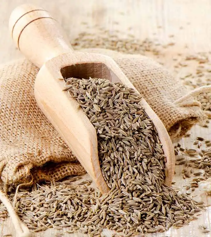 Whole cumin seed in a wooden scoop